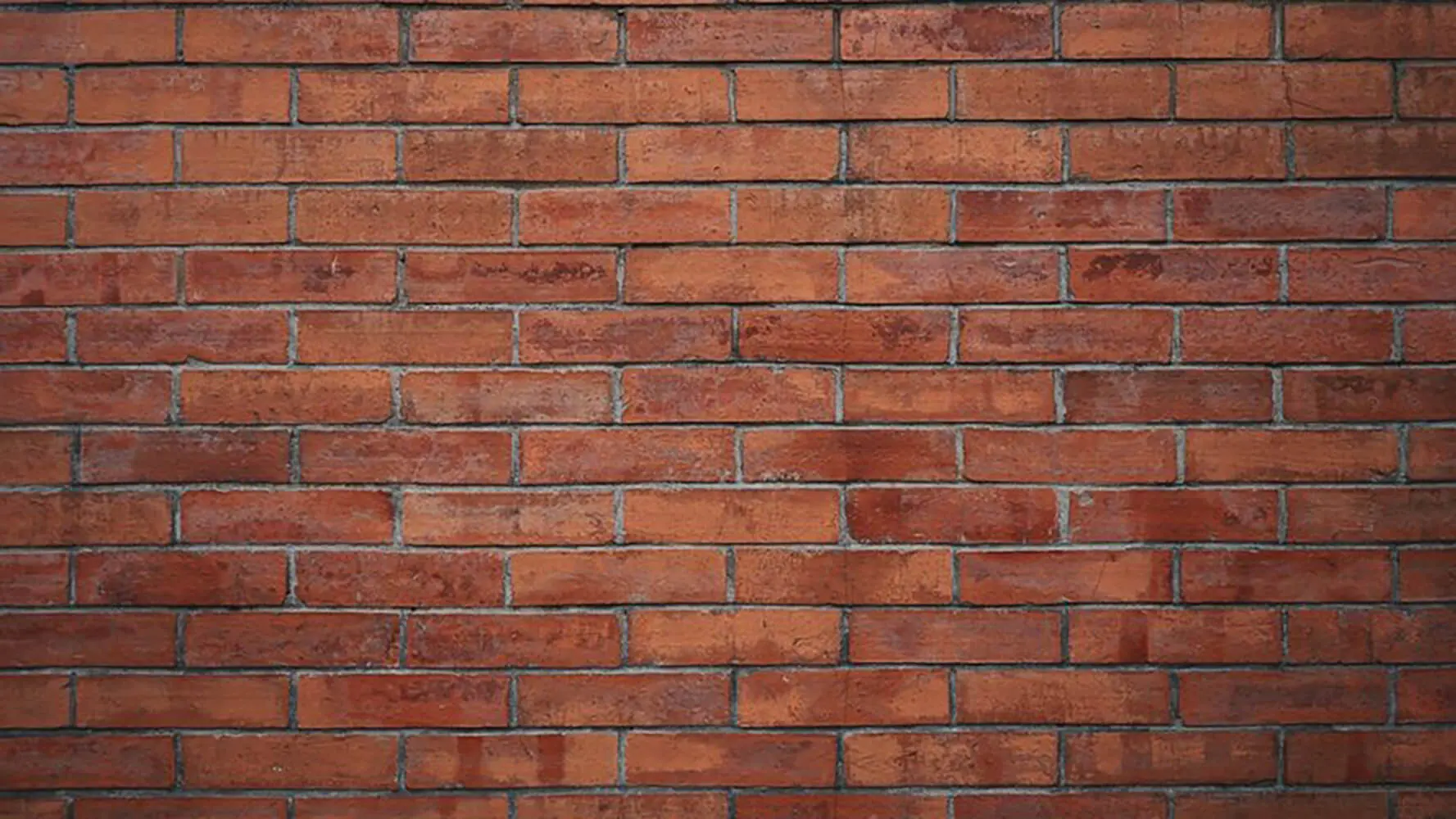 Close-up of a natural red brick exterior wall showing mortar joints and masonry texture, relevant to whether it is better to stain or paint brick.